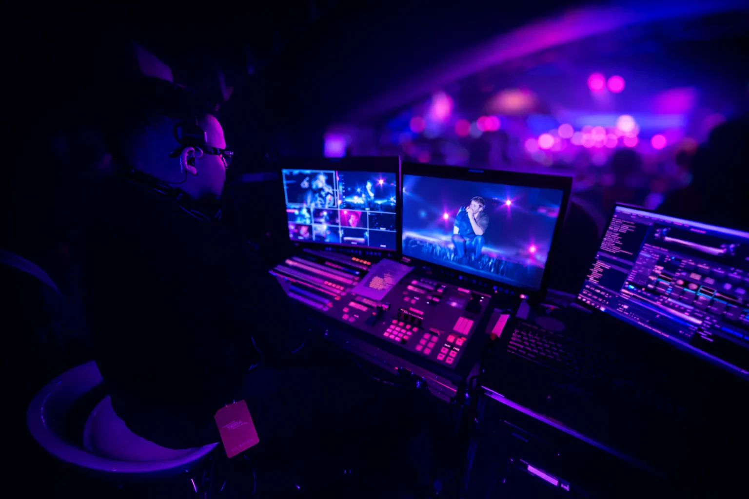 A live video director operating a multi-camera control station during a concert.